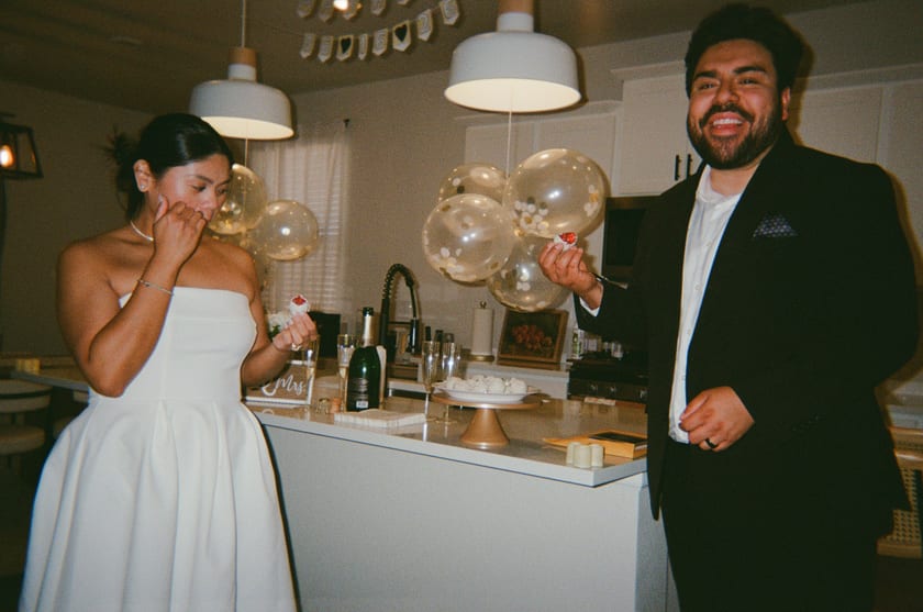 Film photo: happy tears and champagne in the kitchen, balloons overhead