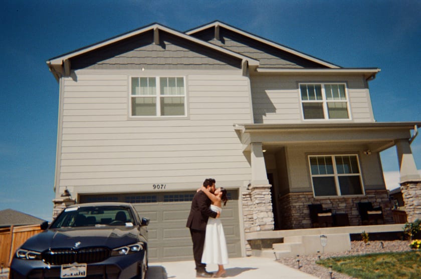 Film photo: a kiss in front of the house, blue sky above