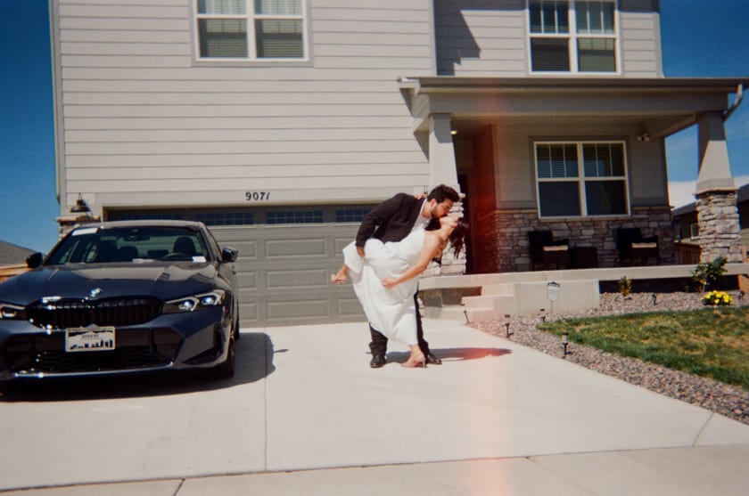 Film photo: carrying the bride across the driveway