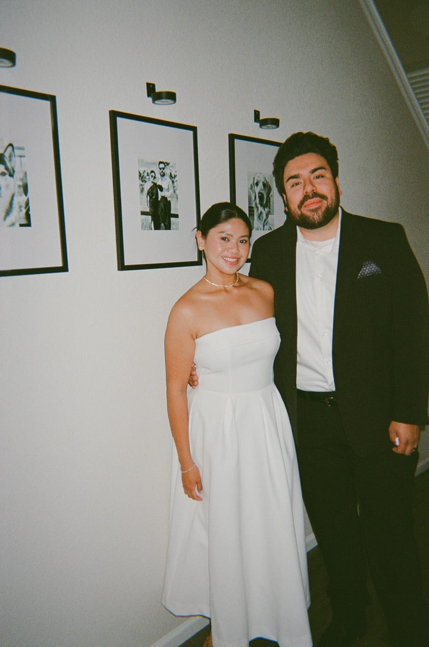 Film photo: standing together beneath the framed photos in the hallway