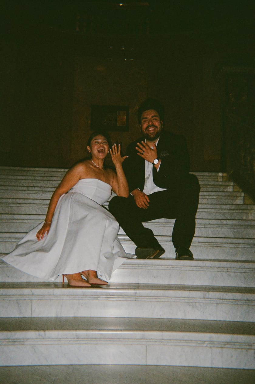 Ann and Chris laughing on the Capitol's marble staircase after the vows
