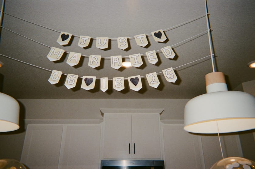Film photo: a hand-stitched heart banner strung across the kitchen