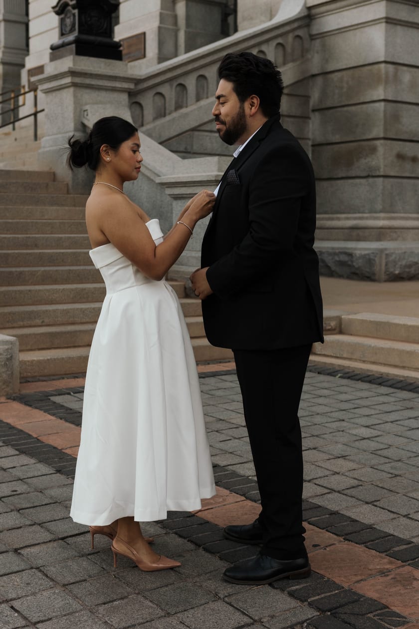 Ann straightens Chris's collar on the Capitol steps before the ceremony