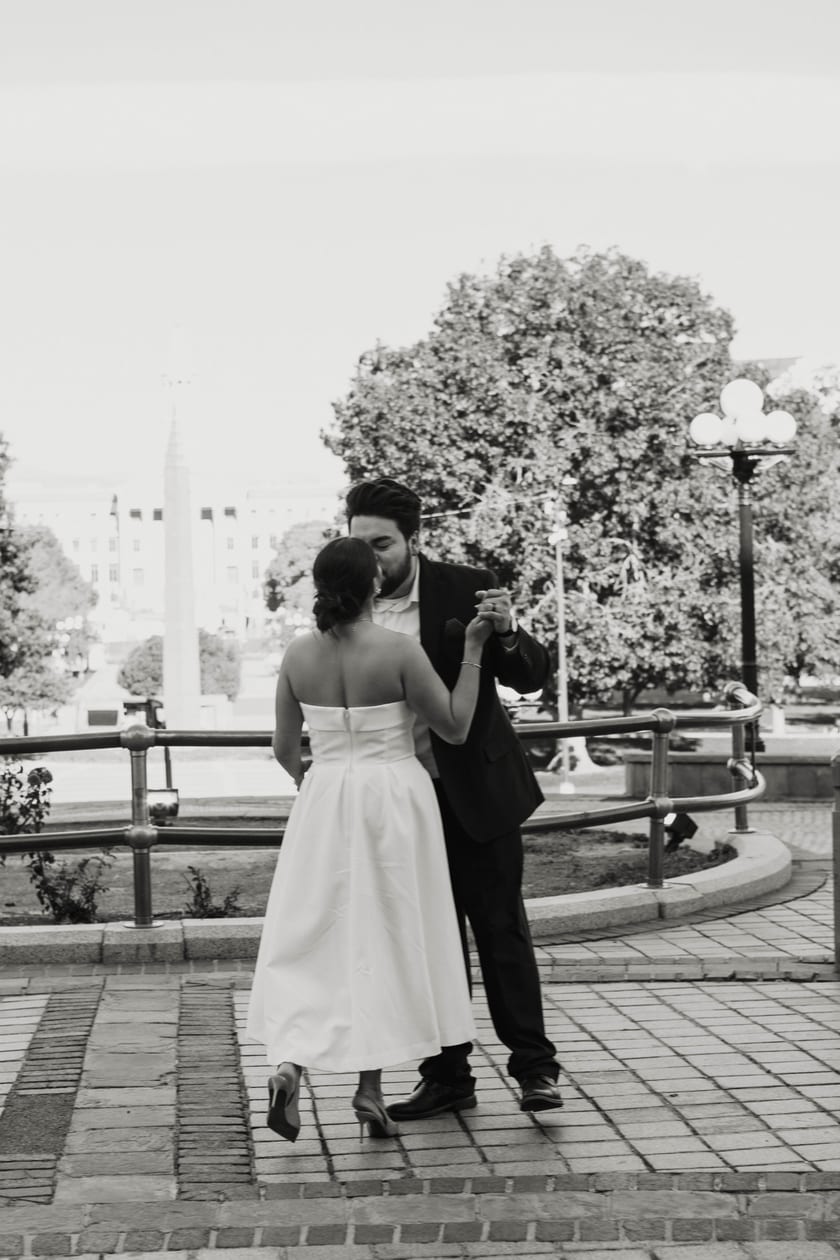 Black-and-white: crossing the Capitol plaza, dress swaying mid-step