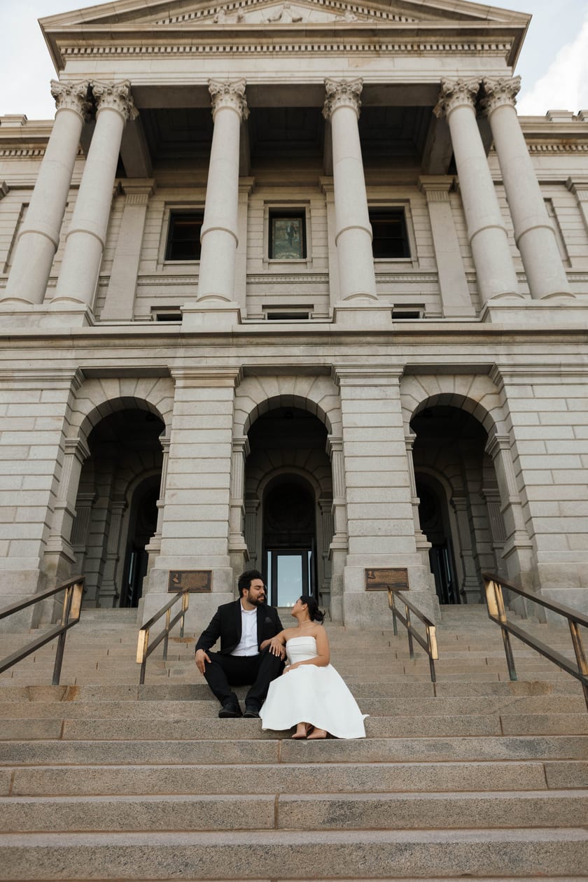 The full Capitol facade rising behind the newlyweds seated on its steps