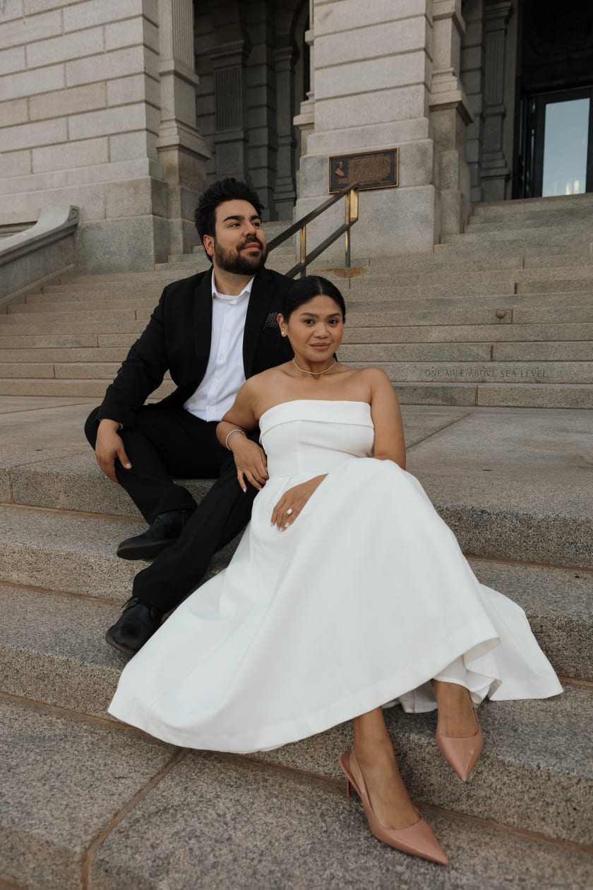 Portrait on the steps, wedding dress draped over warm stone