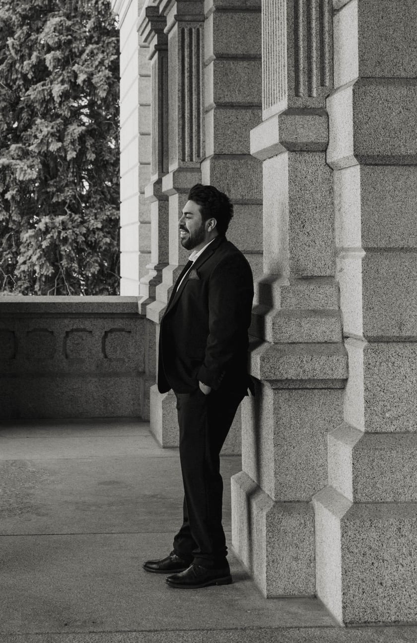 Black-and-white: Chris laughing beside a granite pillar