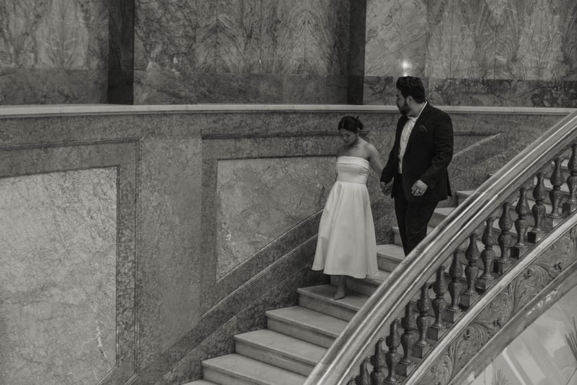 Black-and-white: descending the curved marble staircase hand in hand
