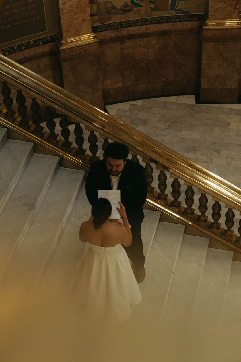 From the landing above: a private vow exchange on the stairs