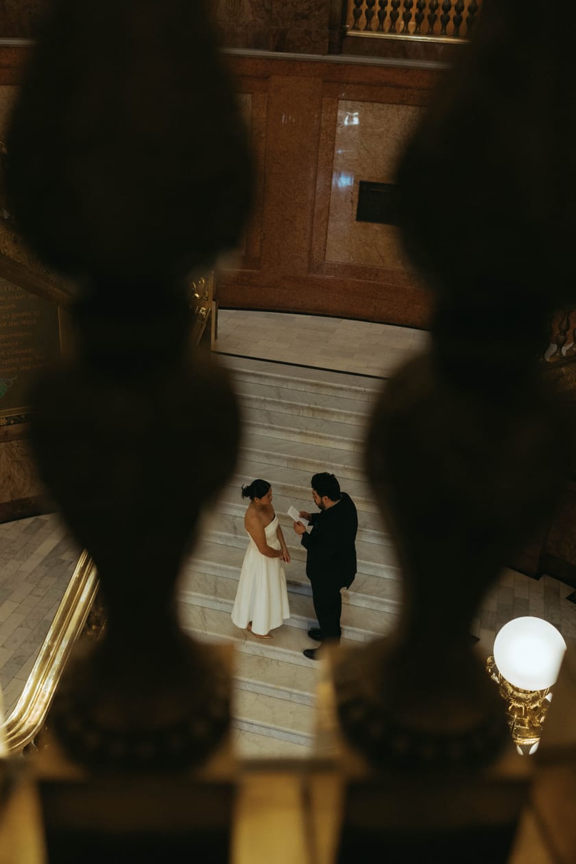Between balusters: the vow exchange from across the hall
